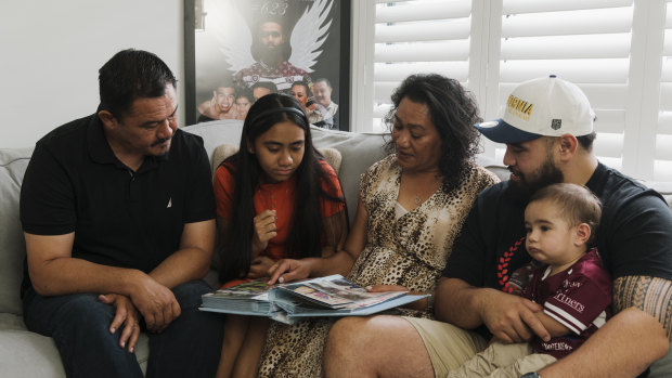 Keith’s dad Paul, sister Zara, mother Lafo, brother Jesse and nephew Hudson looking at family photo albums as they remember the life of their loved one.