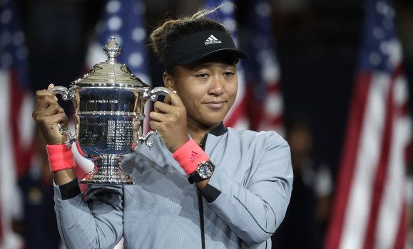 Naomi Osaka, the first Japanese-born winner of a grand slam, holds the US Open trophy after beating Serena Williams.