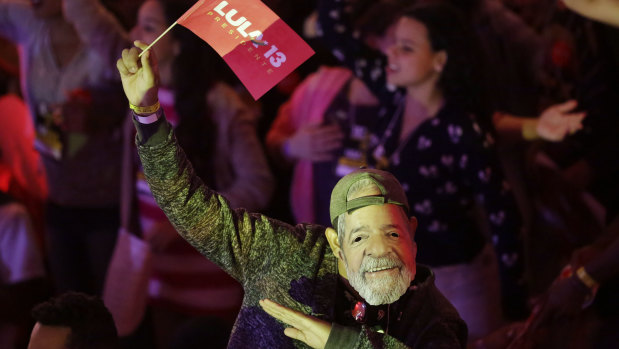 A man wears a mask depicting the Brazil's former President Luiz Inacio Lula da Silva during a Workers Party national convention in Sao Paulo, Brazil, on Saturday.