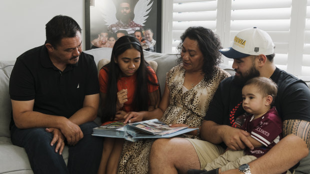 Keith’s dad Paul, sister Zara, mother Lafo, brother Jesse and nephew Hudson looking at family photo albums as they remember the life of their loved one.