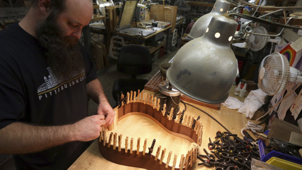 A luthier assembles the rosewood sides of a guitar at C. F. Martin and Co. guitar makers.