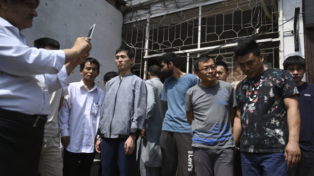 A Pakistani official takes pictures of Chinese nationals detained on trafficking charges.