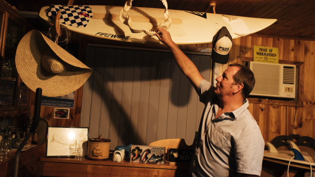 Dave Pearson, with the surfboard on which he was attacked. 