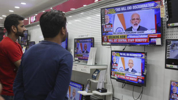 Indians watch Prime Minister Narendra Modi address the nation.