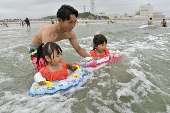 A family plays in the water at Kitaizumi Kaisui beach in Minamisoma, Fukushima Prefecture, after the beach opened to the public for the first time since 2011. 