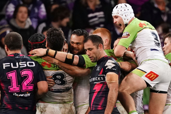 Josh Papalii of the Raiders is congratulated by his teammates after scoring the match-winning try as Storm's Cameron Smith looks on. 