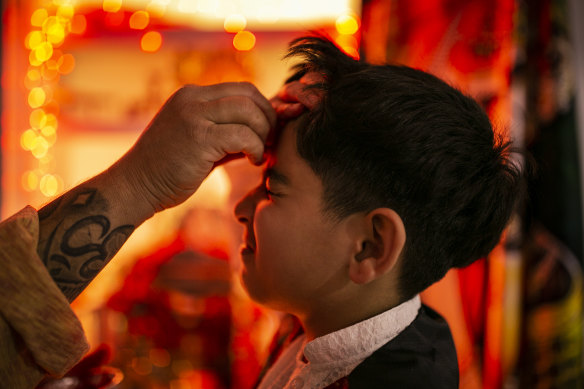 Ram Khatiwada’s eldest son has a tika put on his forehead for Diwali.