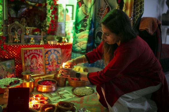 Iswara Khatiwada lights candles near her home for Diwali.