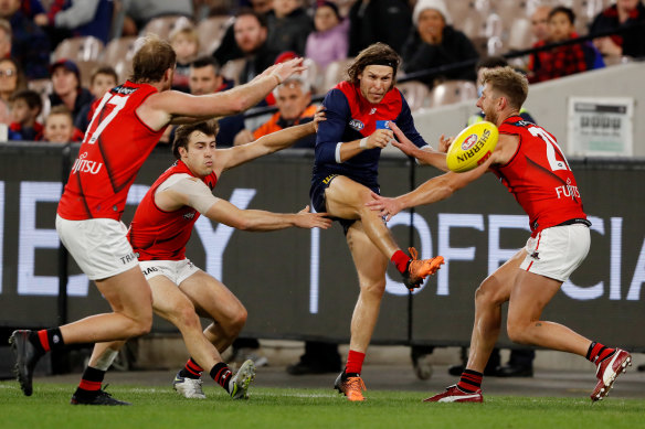 Melbourne’s Ed Langdon threads through Bombers to kick a goal. 