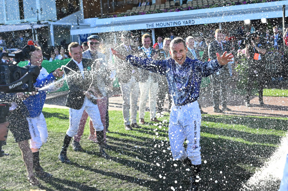 Damien Oliver is sprayed with champagne.