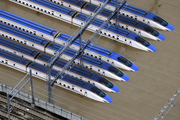 Bullet trains sit submerged in muddy waters in Nagano, central Japan on Sunday.