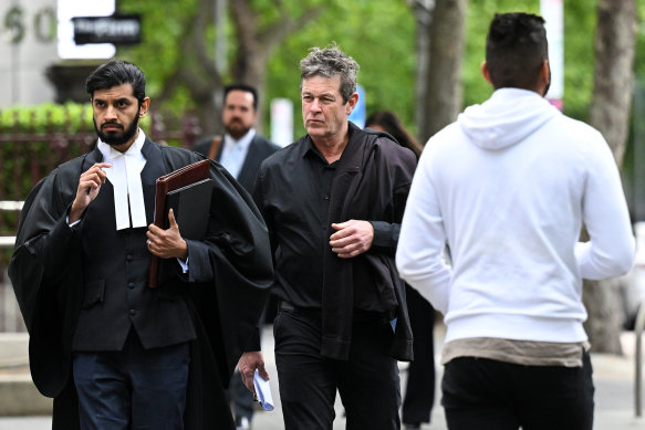 Russel Northe (centre) arrives at the County Court on Wednesday.