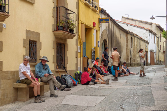 Booking ahead is best … pilgrims wait for the afternoon opening of their hostel.