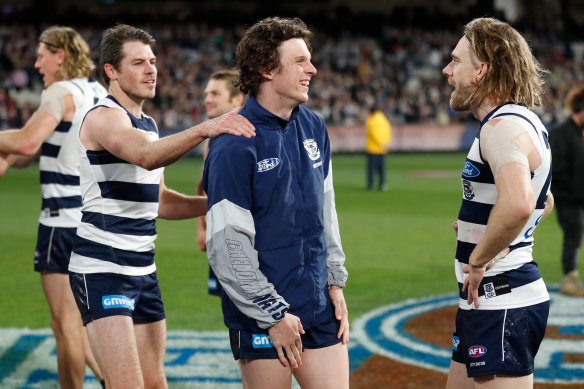 Max Holmes (middle) speaks with Isaac Smith and Cameron Guthrie after the Cats made the AFL grand final.