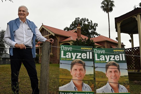 Former Nationals MP George Souris stands outside his home with a poster for current candidate David Layzell.