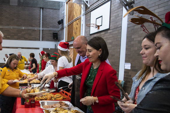 Premier Gladys Berejiklian and Emergency Services Minister David Elliott serve Christmas lunch to firefighters at Colo Heights.