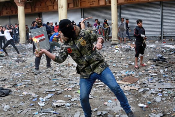 An anti-government protester prepares to throw a molotov cocktail during clashes in Baghdad last week. 