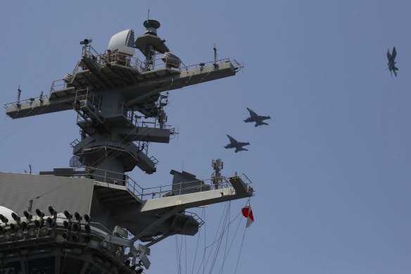 Three EA-18G Growlers fly over the Nimitz-class aircraft carrier USS Abraham Lincoln in Arabian Sea. 