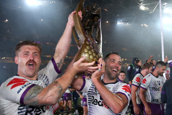Cameron Munster and Cameron Smith lift up the trophy for the Melbourne Storm.