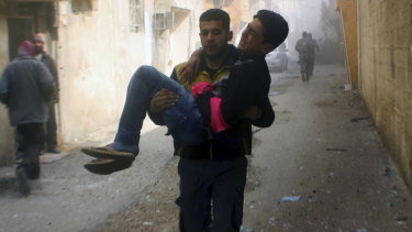 Members of the Syrian Civil Defence group carrying a young man who was wounded during airstrikes and shelling by Syrian government forces, in Ghouta, a suburb of Damascus, Syria. 