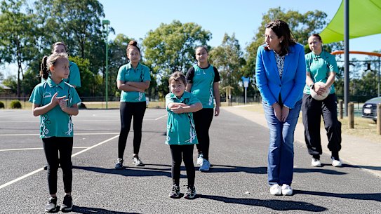 Queensland Premier Annastacia Palaszczuk (right) is seen with members of the Lakers Netball Club following a community sport funding announcement at C.J Greenfield Park in the Brisbane suburb of Richland, Sunday, May 24, 2020.  Queensland sports clubs will receive a boost from a multimillion dollar package from the State Government to make community sport safe. (AAP Image/Dave Hunt)
