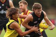 MELBOURNE, AUSTRALIA - MAY 19: Brayden Ham of the Bombers is challenged by Tex Wanganeen and Dyson Heppell during an Essendon Bombers AFL training session at The Hangar on May 19, 2022 in Melbourne, Australia. (Photo by Robert Cianflone/Getty Images)