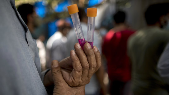 A man waits with his sample at a Covid-19 testing station in New Delhi, India, on Friday.