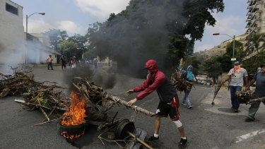 Protesters create burning roadblocks during clashes with security forces as they show support for a mutiny by a National Guard unit.