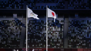 The Olympic flag is raised alongside the Japanese flag.