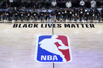 Members of the New Orleans Pelicans and Utah Jazz take a knee before Friday's NBA season resumed.