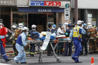 First responders carry a stretcher after a deadly fire at clinic in Osaka on Friday.