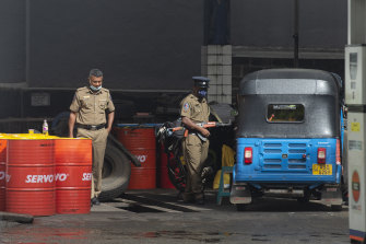 Police officers stand guard at a petrol station in Colombo, Sri Lanka, on Monday, May 16, 2022.
