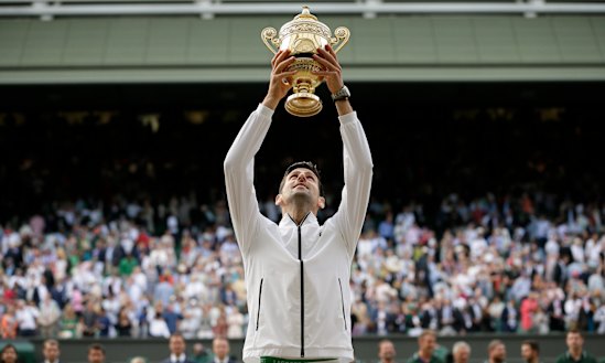 Novak Djokovic lifts the trophy after defeating Switzerland's Roger Federer at Wimbledon in 2019