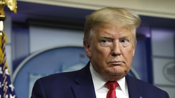 Not for him: US President Donald Trump listens as other discuss using masks.