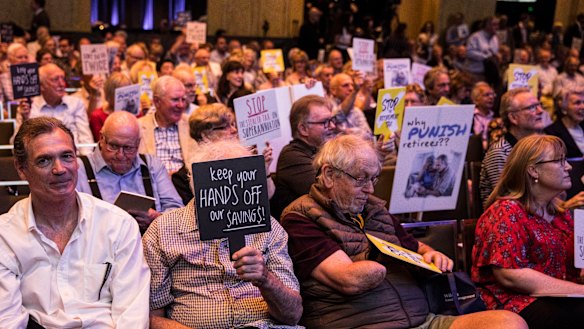 Opponents to Labor's dividend imputation policy change at a recent protest. Bank valuations could be sliced by up to 13 per cent.
