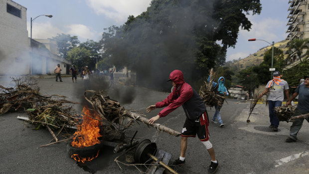 Protesters create burning roadblocks during clashes with security forces as they show support for a mutiny by a National Guard unit.