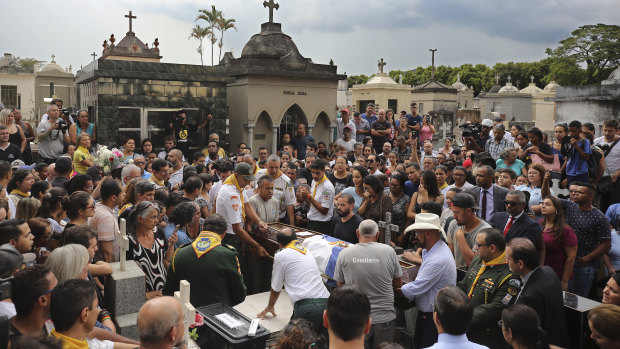 Friends and relatives gather for the burial service for Samuel Oliveira, 16. 