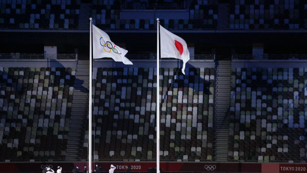 The Olympic flag is raised alongside the Japanese flag.