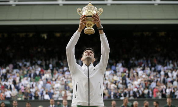 Novak Djokovic lifts the trophy after defeating Switzerland's Roger Federer at Wimbledon in 2019