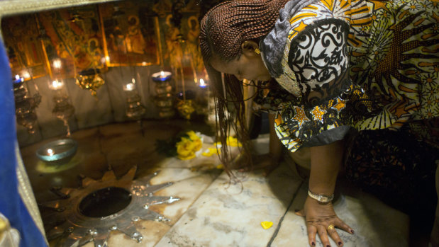A Christian worshipper prays at the Grotto, under the Church of the Nativity.