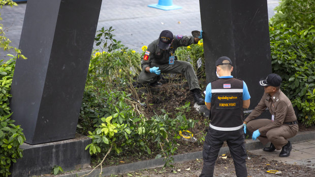 Thai investigators examine a site of an explosion that injured people in Bangkok on Friday.