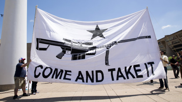 Demonstrators hold a large banner that reads "Come And Take It," during a pro-gun rally on the sidelines of the National Rifle Association annual meeting in Dallas, Texas.