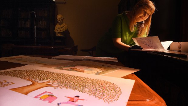 NSW State Library curator Sarah Morley inspects illustrations by children’s author and illustrator Pamela Allen.