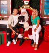 Santa Harold poses for a photo with photographer Simone Morihovitis (right), her partner Ben Cerni and dog Boof recently at Greensborough Plaza shopping centre.