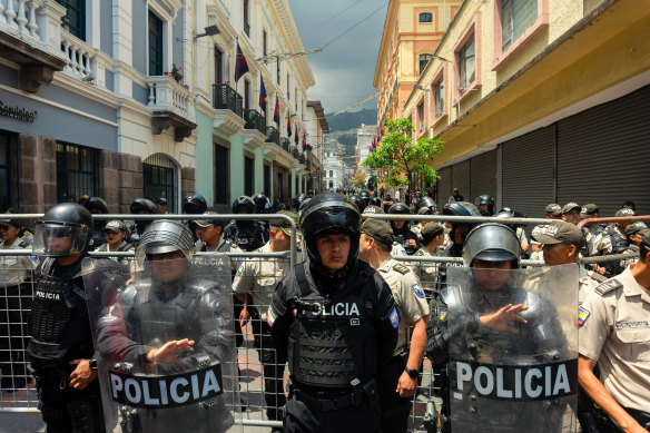 Police officers block the street during a demonstration in Quito, Ecuador.