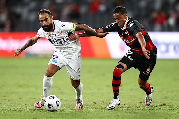 Perth’s Spanish star Diego Castro holds off Keanu Baccus.