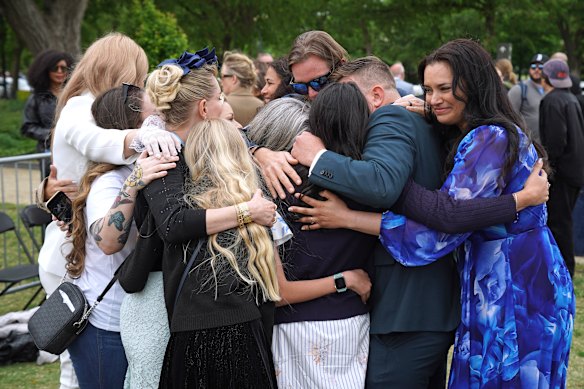 The Roberts family and survivors embrace each other during the vigil.