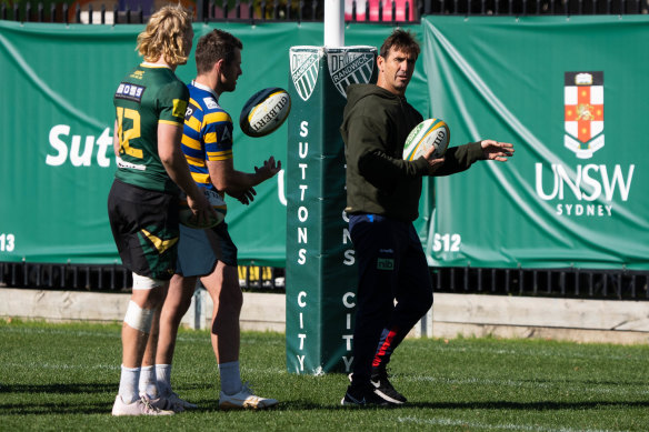 Andrew Johns mentors Bernard Foley and Carter Gordon at Coogee Oval on Friday.