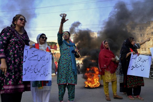 Supporters of Imran Khan’s party chant slogans next to burning tyres on Friday.