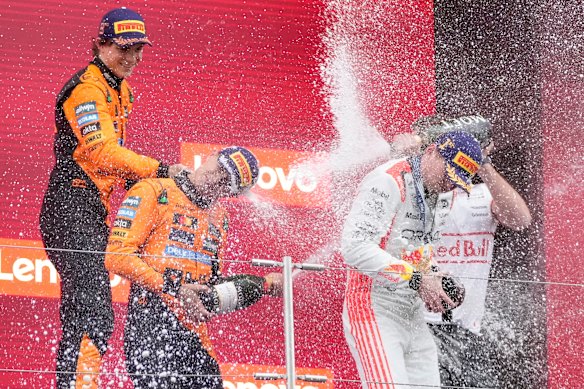 Oscar Piastri and Lando Norris celebrate on the podium with Japanese Grand Prix winner Max Verstappen.